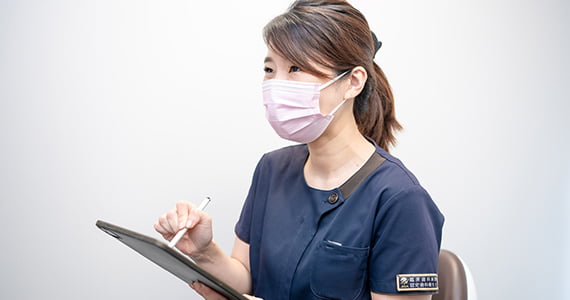 衛生士がタブレットで説明している様子
